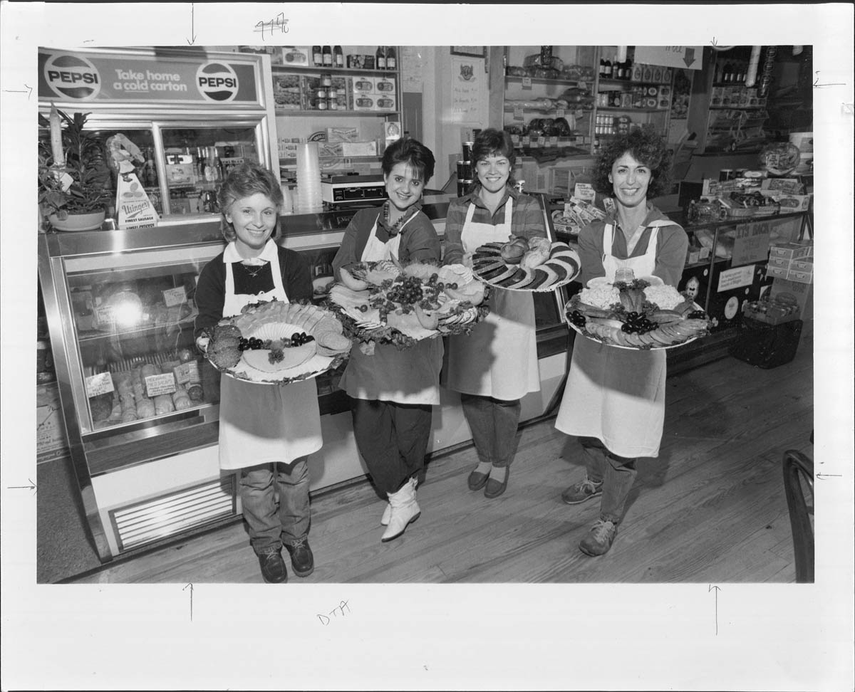 A black and white photo of Katzinger's co-owner Diane Warren and staff holding catering trays