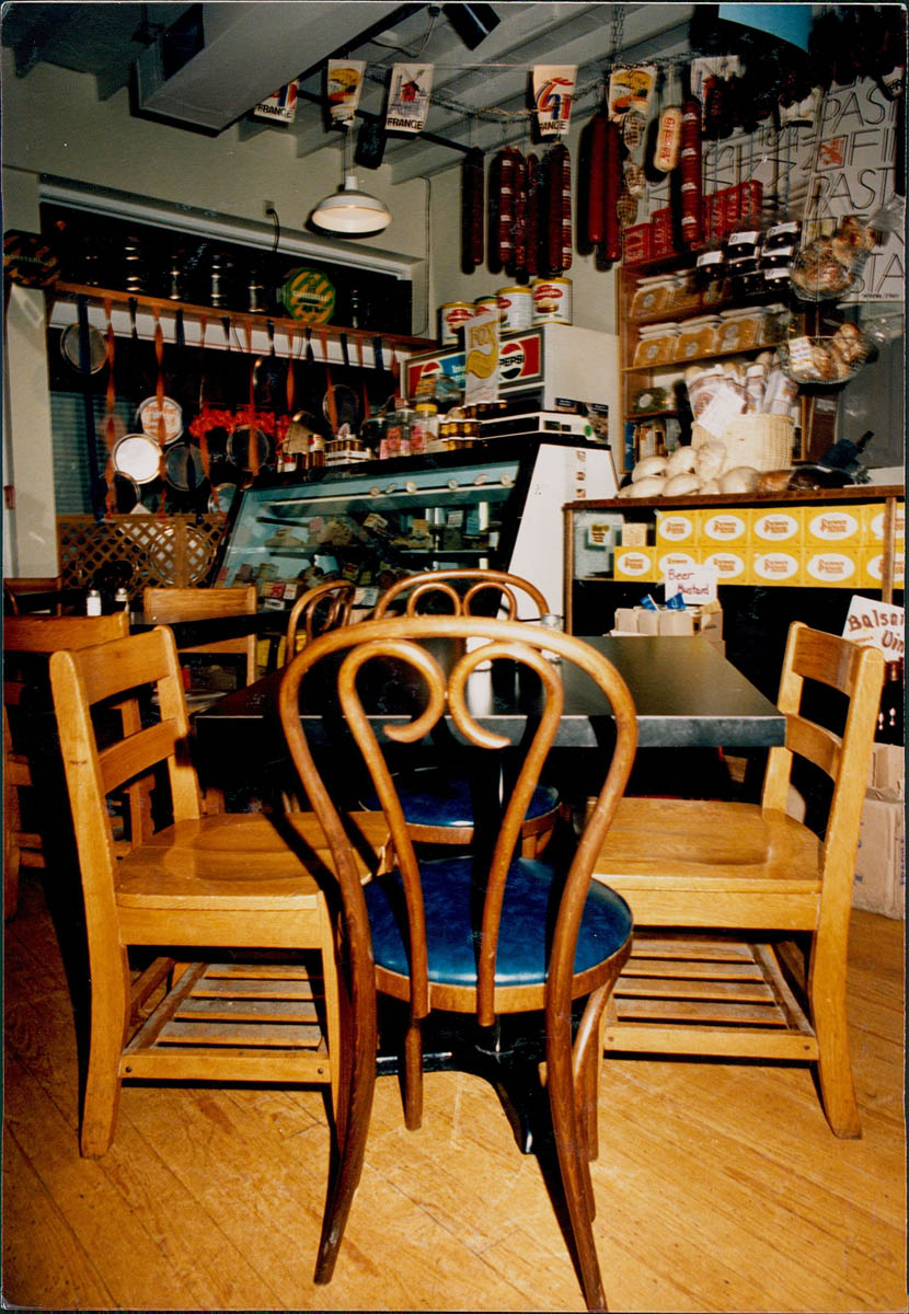 A dining room table in front of the deli case and cash register at Katzinger's Deli.